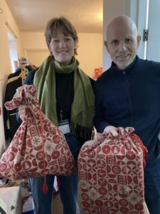 Lucy and Chris holding bags of donations