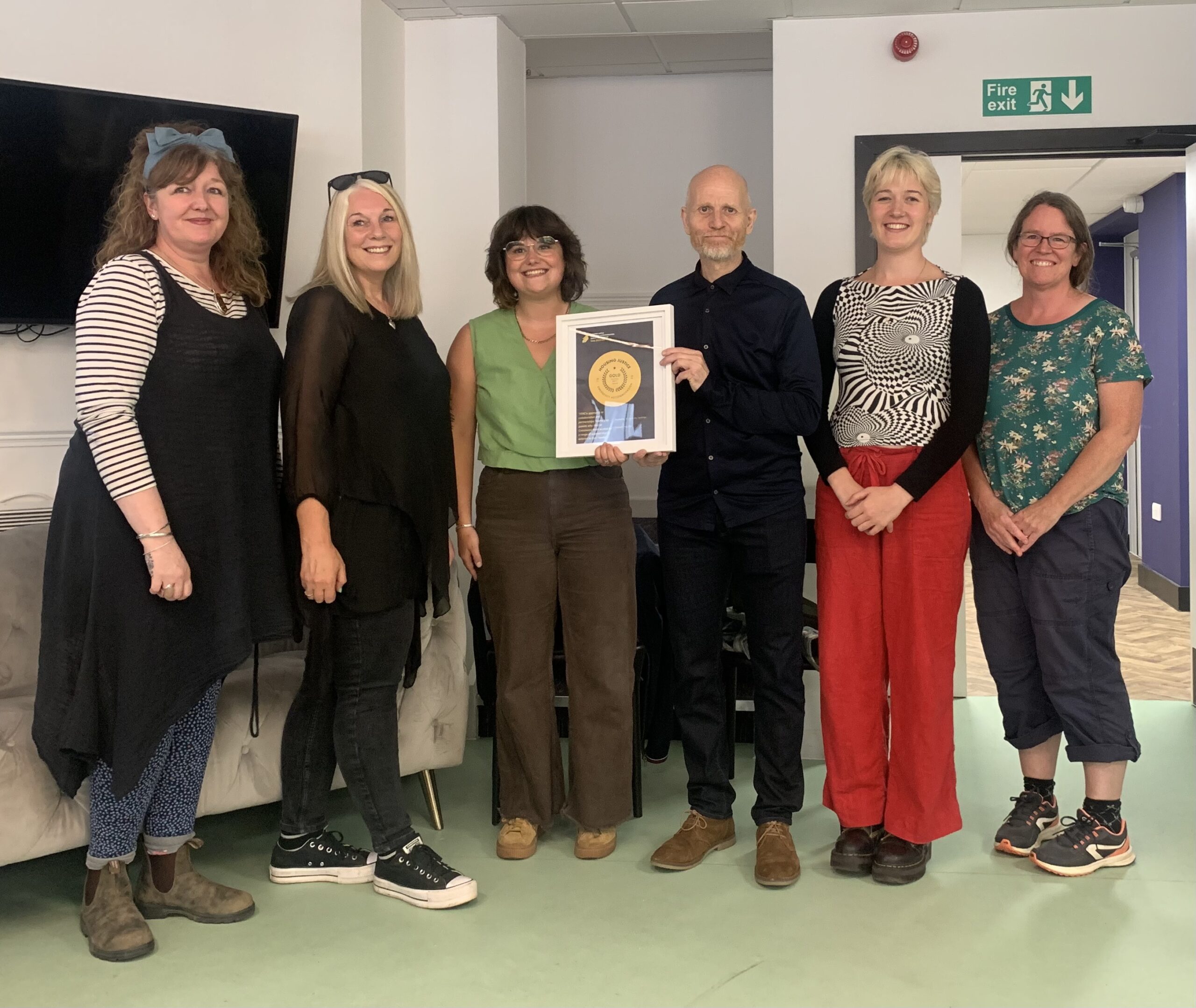 Members of the ITAC team collecting a certificate from Housing Justice.