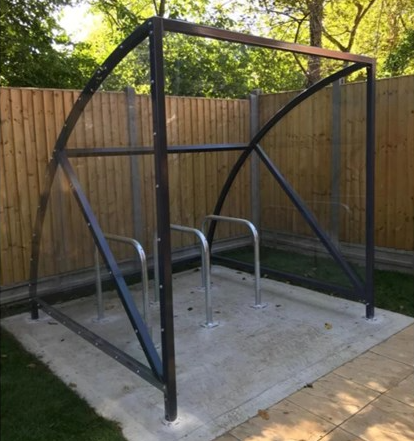 A perspex covered bike shed on concrete base