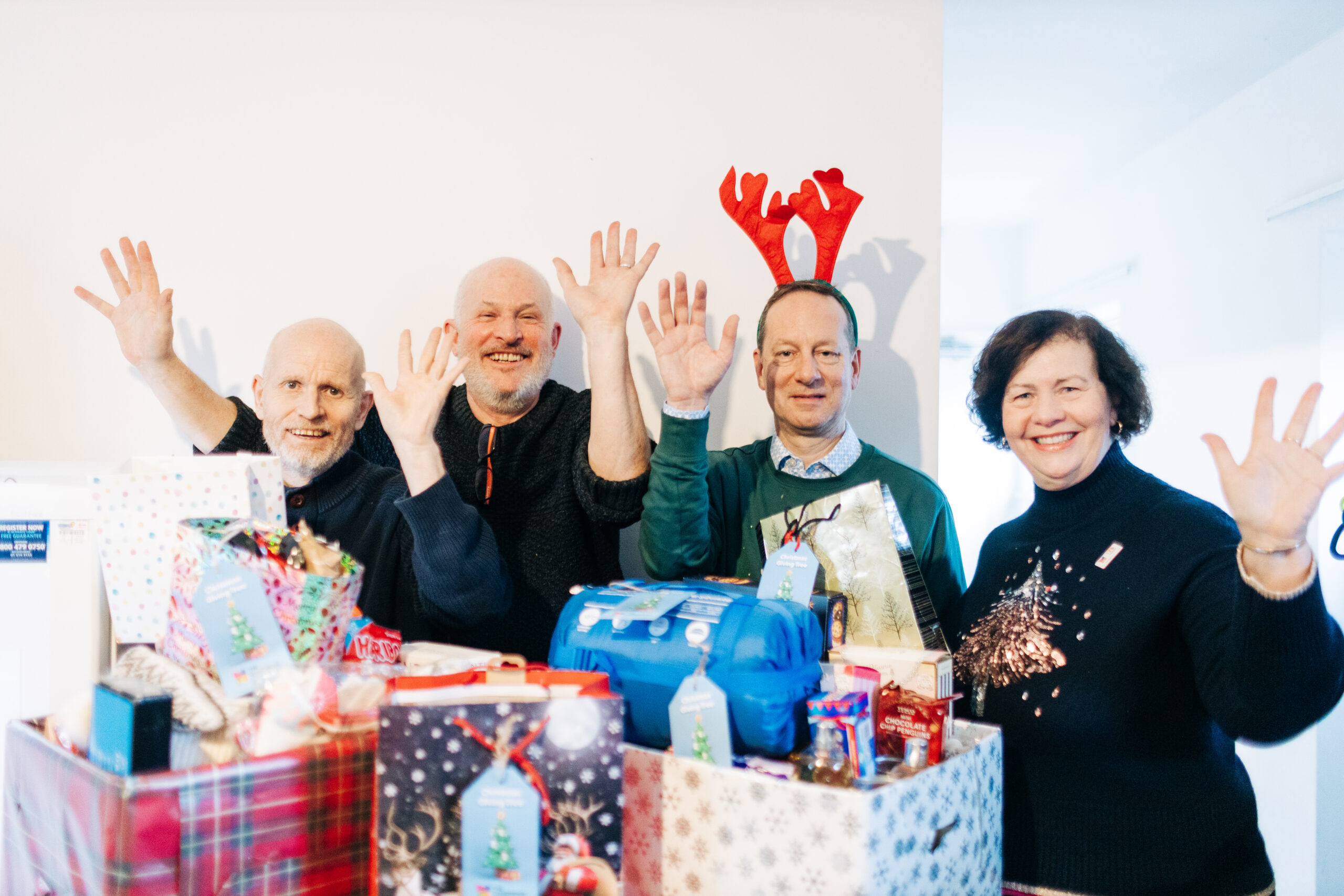 Peter and Joanne from Cambridge Building Society standing with Matt and Chris behind boxes of Christmas donations