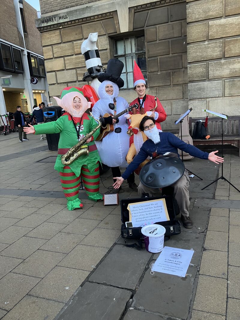 Sophie and her jazz trio dressed in novelty Christmas costumes outside Cambridge Guildhall