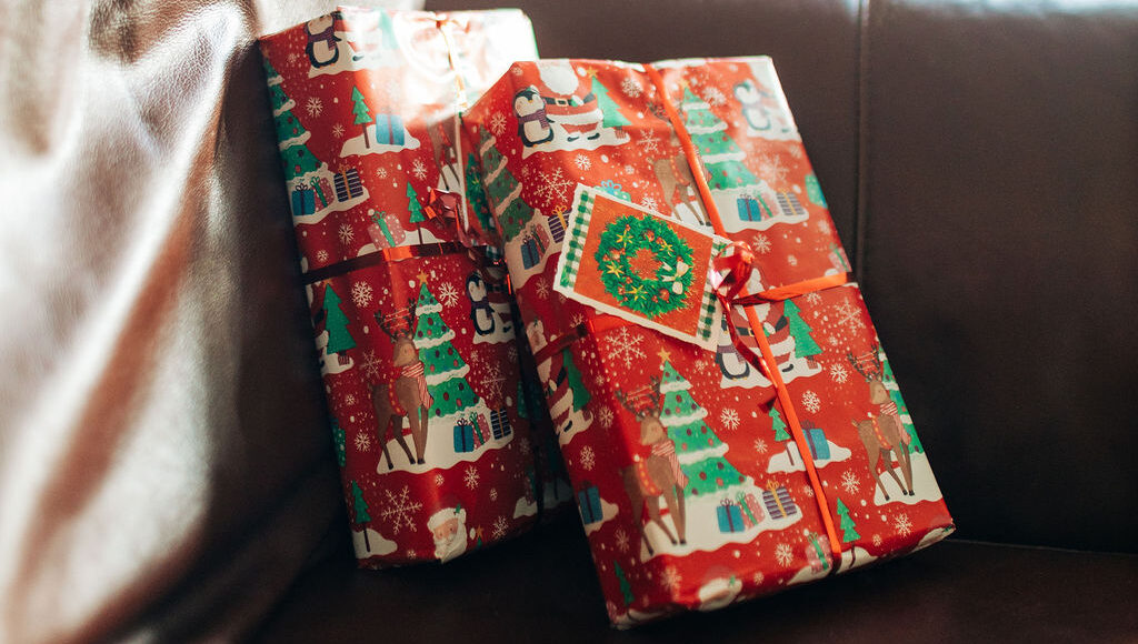 Two Christmas presents on a dark brown sofa