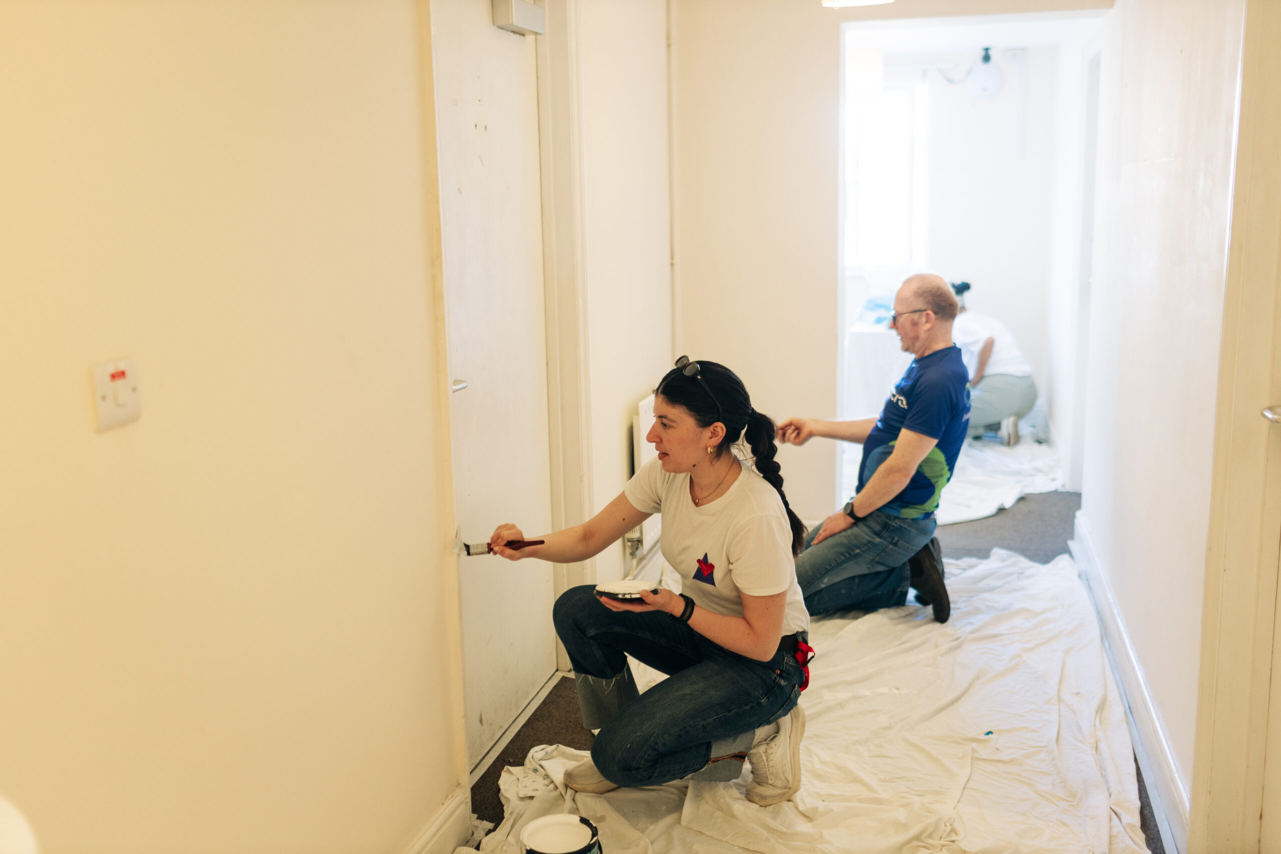 Two volunteers from Cogentia paint a corridor at Crossways