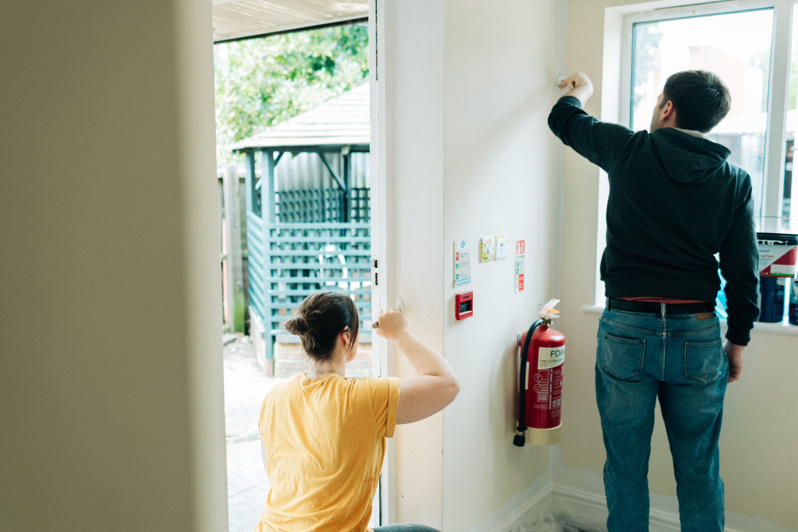 Two volunteers from Cogentia painting a door at Crossways